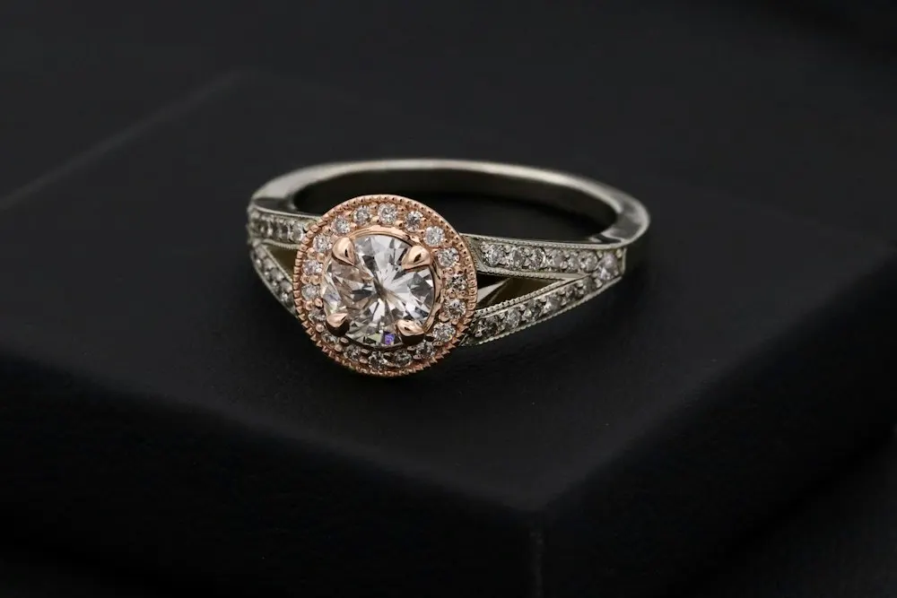 Imagen de referencia: anillo con piedra central y halo en oro rosado y blanco