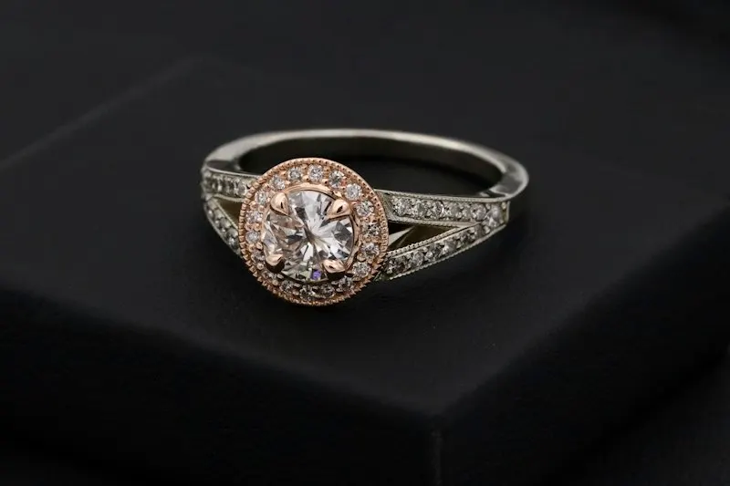 Imagen de referencia: anillo con piedra central y halo en oro rosado y blanco
